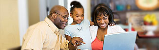 Picture of two parents with their small daughter looking at a laptop.