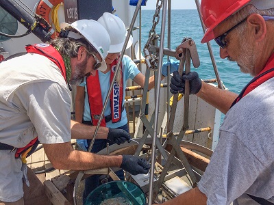 EPA Region 6 staff collecting sediments from a grab sample on an ocean disposal site monitoring survey.