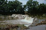 Photo of a stream with water breaking over a dam.