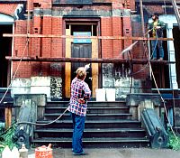 Photo of a worker striping paint off a building may be a source of toxic waste in rivers and streams.