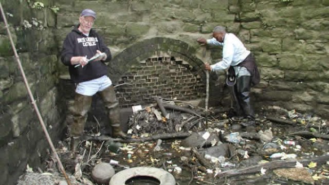 Volunteers at blocked stream channel culvert.