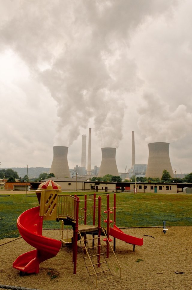 Playground in foreground with nuclear smoke stacks in the background