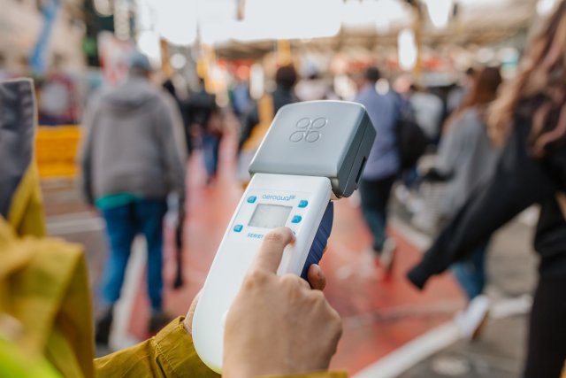 A small air sensor takes measurements on a busy street