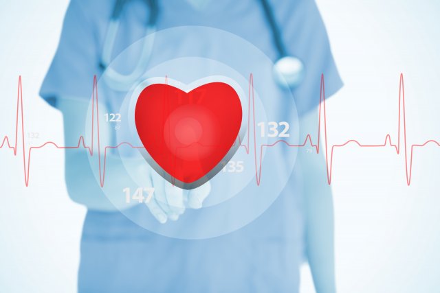 A doctor holds a heart graphic in their hand