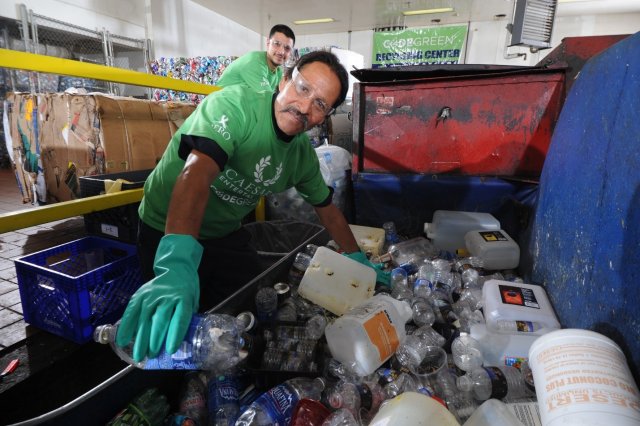 This is a picture of two men recycling plastic bottles.