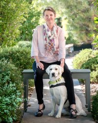 Missy sitting on a bench with her dog Glacier.