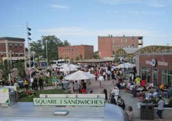 street festival with lots of people in open area surrounded by buildings