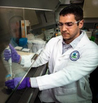 Researcher analyzing a sample for a chemical agent