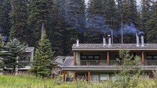 House with woodstove chimney releasing smoke