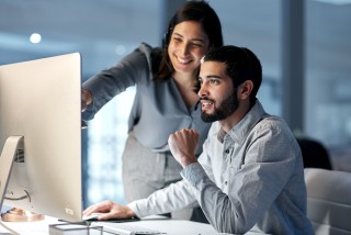 Two people looking at a computer screen.