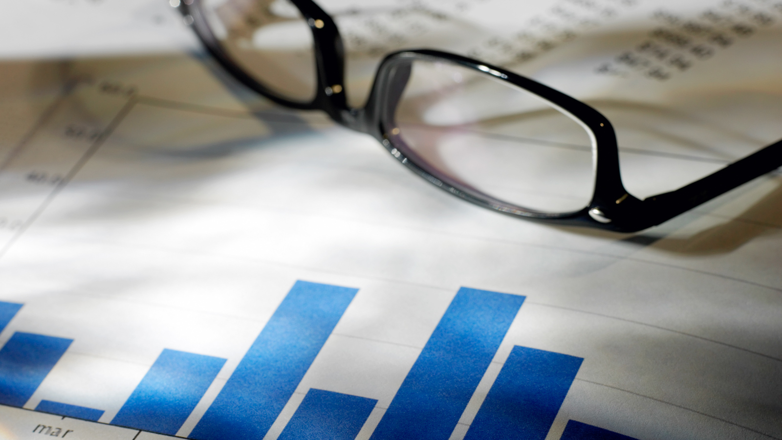 Image of a pair of glasses resting on some paperwork. 