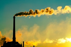 A smokestack silhouetted by the sunset