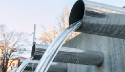 Clear water pours from industrial pipes