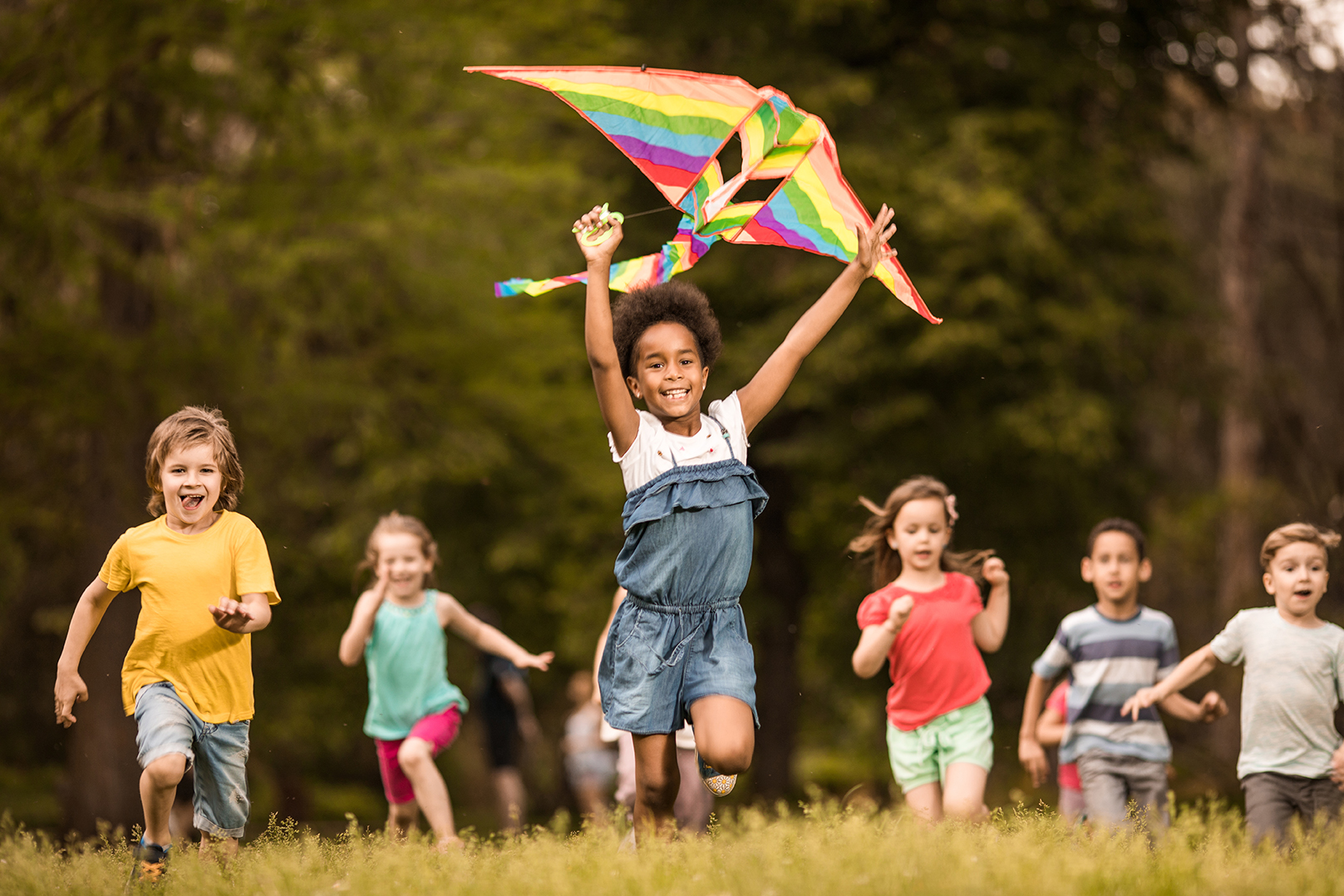 Kids running outside with a kite