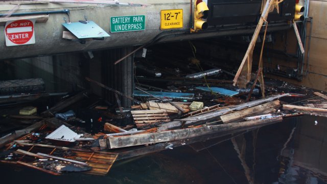 View of Battery Park tunnel with flooded entrance filled with building wreckage in front.