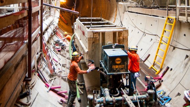 Workers in tunnel constructing sewer system