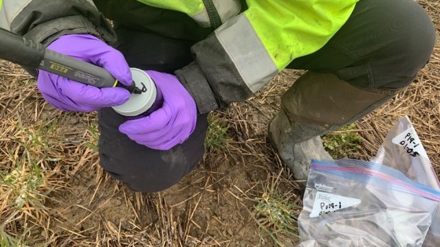 Person collecting soil and labeling container