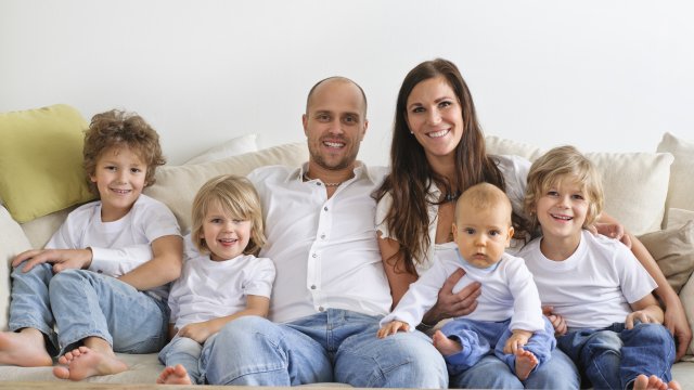 Family indoors with four children on the couch