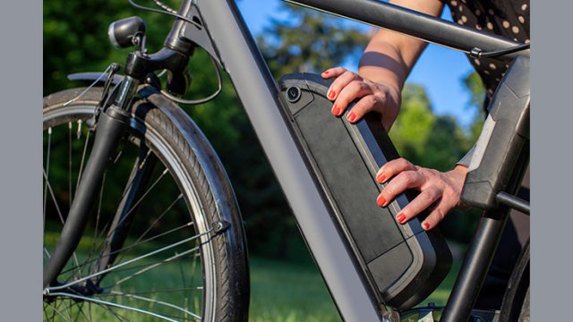 electric bike focused in on a person putting the battery on the bike.