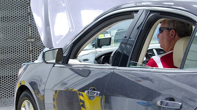 man sit in a car in a vehicle testing lab