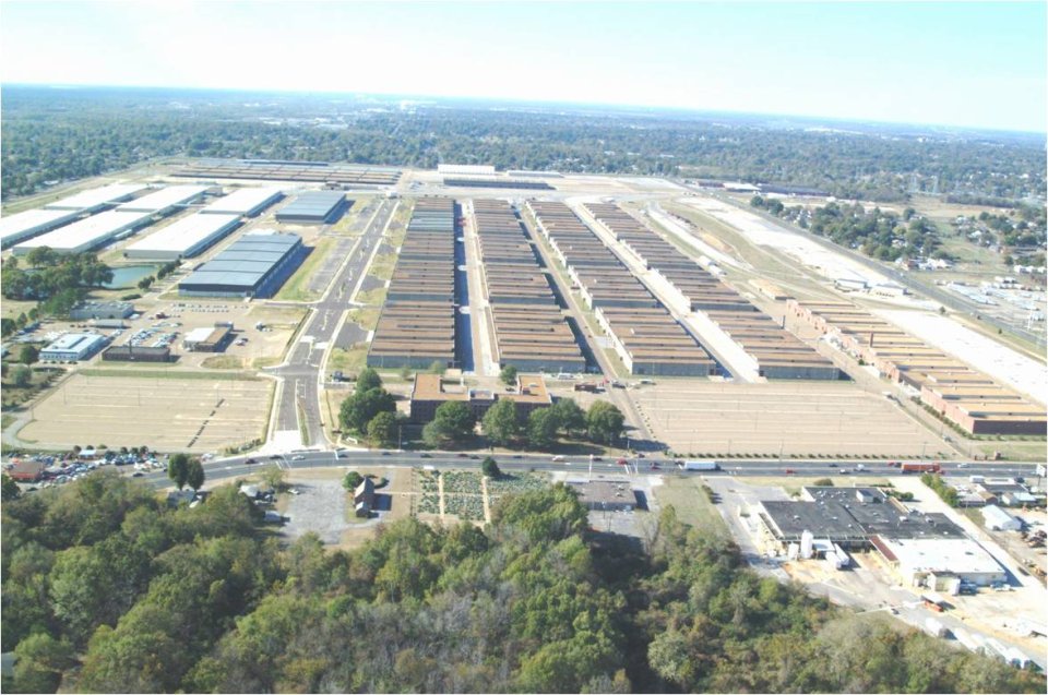 An aerial photo showing rows of buildings surrounded by roads and trees.