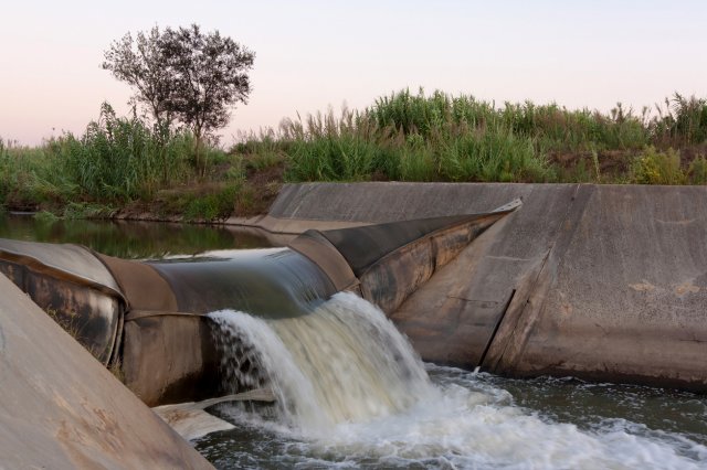 Inflatable dam used to slow flow in a contamination event