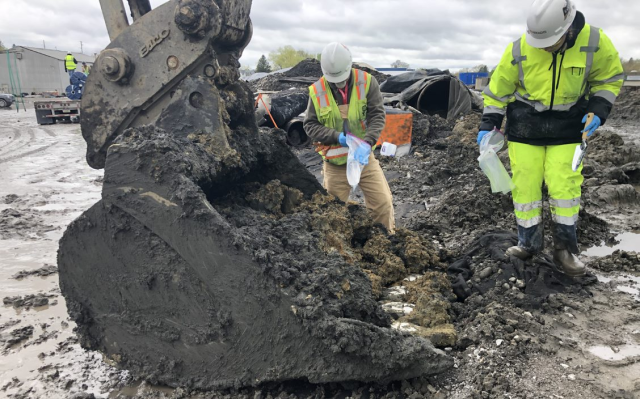 Two people sampling excavated material from the north track