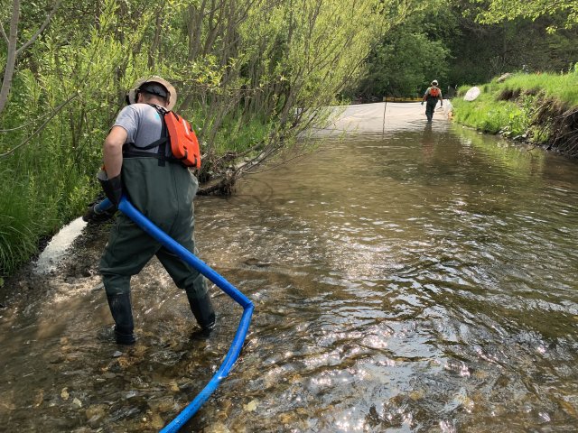 Man standing in the stream with equipment