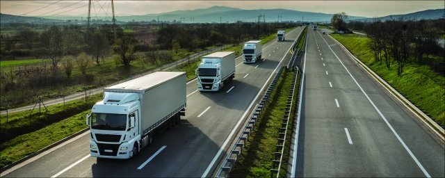 This is a picture of several trucks driving down a highway.