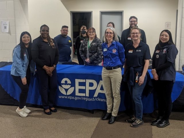 A group of people standing at an EPA booth