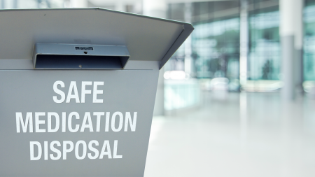 gray metal box for the safe disposal of medication in a lobby of a building