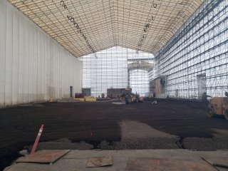 Interior of the Full Enclosure Unit showing containment structure, excavation equipment, and bare soil