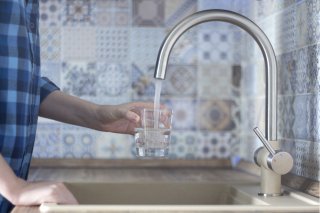 Filling glass of water in sink