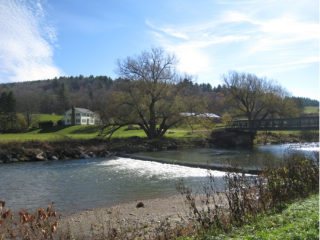 Showing a river and a house on a hillside in Vermont