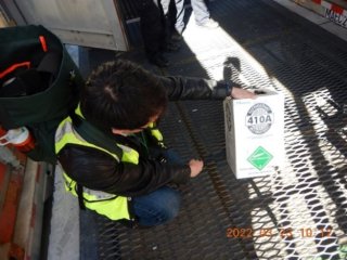 EPA inspector looking at a package labelled 410A, an HFC, while on inspection at a port.