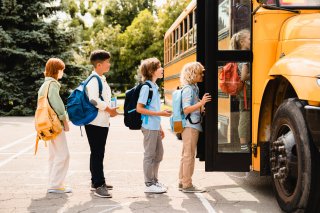 Children wait in line to enter school bus