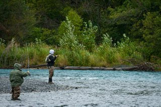 A few people fishing in a river