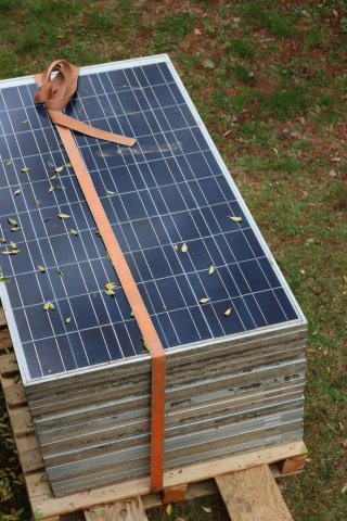 Pile of used solar panels strapped together. 