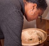 person bent over taking a drink from a water fountain.